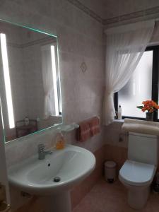 uma casa de banho com um lavatório, um WC e um espelho. em Manor Court Luxury Apartment em St. Paul's Bay