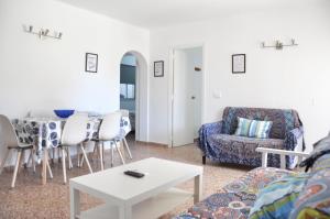 una sala de estar con un sofá y una mesa en Apartamentos Las Rosas, en Denia