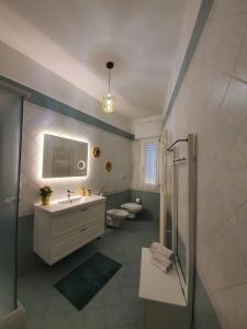 ein Badezimmer mit 2 WCs, einem Waschbecken und einer Dusche in der Unterkunft Maison Borgomare in Monopoli