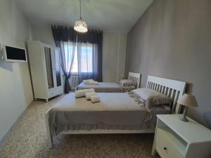 1 Schlafzimmer mit 2 Betten und einem TV in der Unterkunft Maison Borgomare in Monopoli
