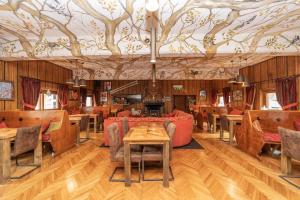 ein Restaurant mit Tischen und Stühlen und einer Decke mit Bäumen in der Unterkunft Hotel Gran Baita in Sauze dʼOulx
