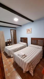 2 camas en una habitación con paredes azules en Casa Mariana en Lubián