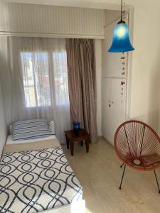 1 dormitorio con cama, lámpara azul y silla en Park, en Agioi Theodoroi