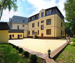 a large yellow building with a large courtyard at Sanatoriy Imeni Anzhievskogo - Korpus Villa German in Essentuki