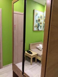 zielony pokój z łóżkiem i lustrem w obiekcie Anastasios Luxury Apartment Sea View w Retimnie