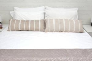 a white bed with two pillows on top of it at Sunny Apt at Regina Apartments in Zakynthos Town