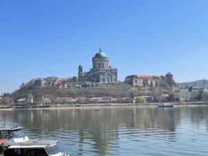 a building on an island in the water with boats at Lovely Apartment Vadaš in Štúrovo