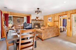 a living room with a table and a couch and a fireplace at Montana Cabin - 1938 by Big Bear Vacations in Big Bear City