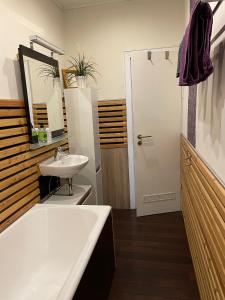 Un baño con bañera, lavabo y espejo. en Ferienwohnung an der Sesselbahn, en Cochem