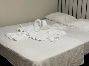 a bed with white sheets and towels on it at ANCA apartment in Paleo Tsifliki