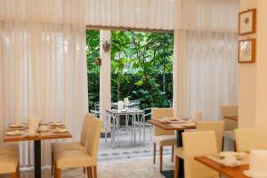 a dining room with a table and chairs and a window at Hotel Lido in Grado