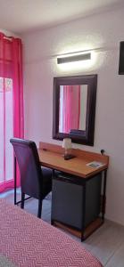 a bedroom with a desk with a mirror and a chair at Hotel Hélios in Cap d'Agde