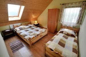 a bedroom with two beds in a wooden house at Beskidnik in Polańczyk