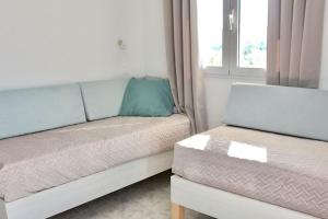 a living room with a couch and a window at Sunny Apt at Regina Apartments in Zakynthos Town
