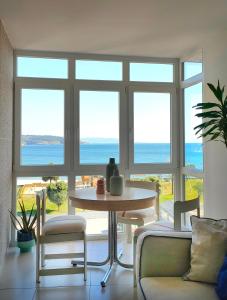 a living room with a table and a view of the ocean at A casa da sardiña. Unha parada no Atlántico in Fisterra