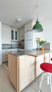 a kitchen with a wooden island with a red stool at A casa da sardiña. Unha parada no Atlántico in Fisterra