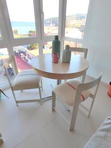 a table and chairs in a room with a window at A casa da sardiña. Unha parada no Atlántico in Fisterra
