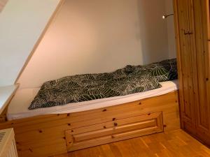 a bed with a black and white comforter on it at Haus am Meer in Nordstrand