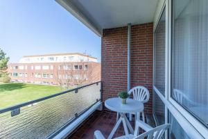 a balcony with a table and chairs and a building at Vogelsand 325 in Cuxhaven