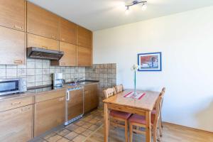 a kitchen with wooden cabinets and a wooden table with chairs at Vogelsand 325 in Cuxhaven +37 photos