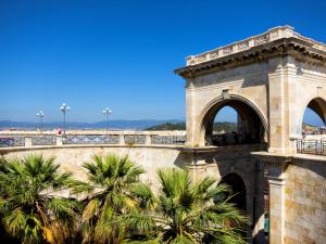 een gebouw met palmbomen en een brug bij Colombohouse87 in Quartu SantʼElena