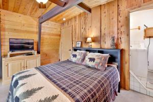 ein Schlafzimmer mit einem Bett in einem Zimmer mit Holzwänden in der Unterkunft Wolf Cub Cabin - 1946 by Big Bear Vacations in Big Bear Lake