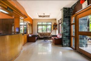 a living room with couches and a bar in a house at Hotel Priti International in Mapusa