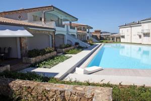 a villa with a swimming pool and a house at Appartamento a due passi dal mare in Palau