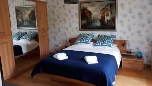 a bedroom with a bed with blue and white pillows at Aux Trois Mûriers in Villeneuve-sur-Lot