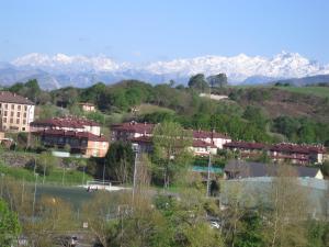 a city with snow capped mountains in the background at Lo de Jaime in Arriondas