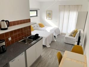 a room with two beds and a kitchen with a sink at DIANA BEACH HOUSE in Albufeira