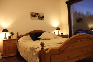 1 dormitorio con cama de madera y ventana grande en Lakeview Houses Sweden - Red House, en Svärdsjö