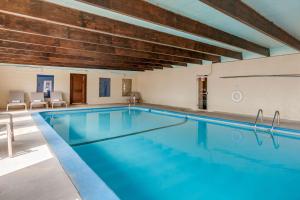 a large swimming pool with blue water in a building at Rodeway Inn & Suites in Ontario