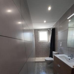 a bathroom with a toilet and a sink and a window at Lo de Jaime in Arriondas +23 photos