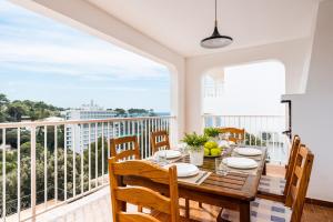a dining room with a table and chairs and a balcony at Villa Spring Hill - Cala Galdana in Ferreries