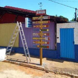 a sign in front of a building with a ladder at Pousada Sírius in São Roque de Minas