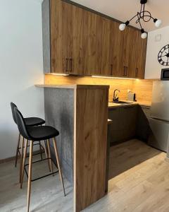 una cocina con una silla negra y una barra en Apartament Wrzeszcz, Kamienice Kołłątaja en Gdansk