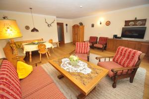 ein Wohnzimmer mit einem Sofa und einem Tisch in der Unterkunft Appartementhaus Alpenrose in Wallgau