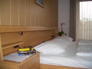 una camera da letto con un letto con testiera in legno di Ferienwohnung Tauberhof a Bressanone Altre 7 foto