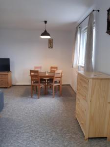 切爾瑪波蘇馬維的住宿－Černá v Pošumaví Apartmán，一间带木桌和椅子的用餐室