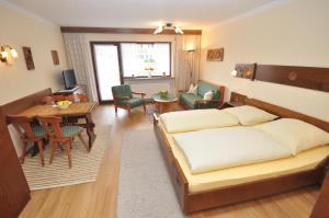 una camera con letto e una sala da pranzo di Appartementhaus Alpenrose a Wallgau