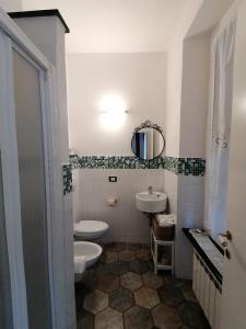 een badkamer met 2 toiletten, een wastafel en een spiegel bij L'Antica Terrazza in Monterosso al Mare
