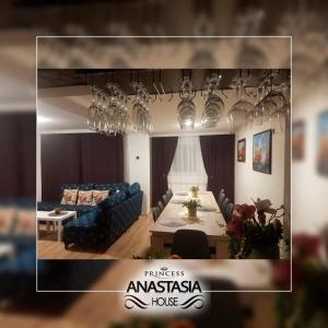 a living room with a blue couch and a table and chandeliers at Къща Принцеса Анастасия in Chiprovtsi
