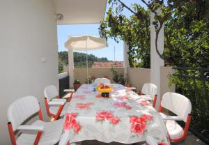 a white table with white chairs and a white umbrella at Apartment Rina - 200 m from beach in Okrug Donji