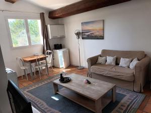 a living room with a couch and a coffee table at Chambres tomate, dans maison avec petit escalier et Stanna, à 6km du festival de piano de la roque d'anthéron in Rognes