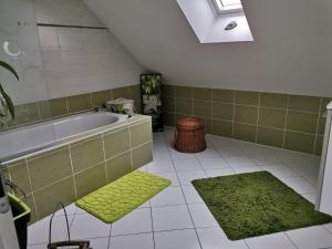 een badkamer met een bad en een groen tapijt bij laurilia in Saint-Romain-sur-Cher