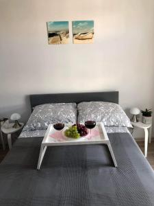 a bed with a tray with a plate of grapes on it at Nadmorski Apartament Dream w Gdańsku in Gdańsk