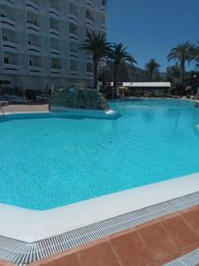 a large swimming pool with blue water at DAC HOME AGAETE PARQUE in Playa del Ingles