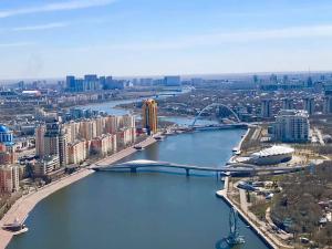 uma vista aérea de uma cidade com um rio e uma ponte em Апартаменты на набережной с панорамным видом на 39 этаже em Astana