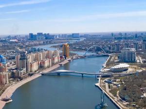 an aerial view of a city with a river and a bridge at Апартаменты на набережной с панорамным видом на 39 этаже in Astana